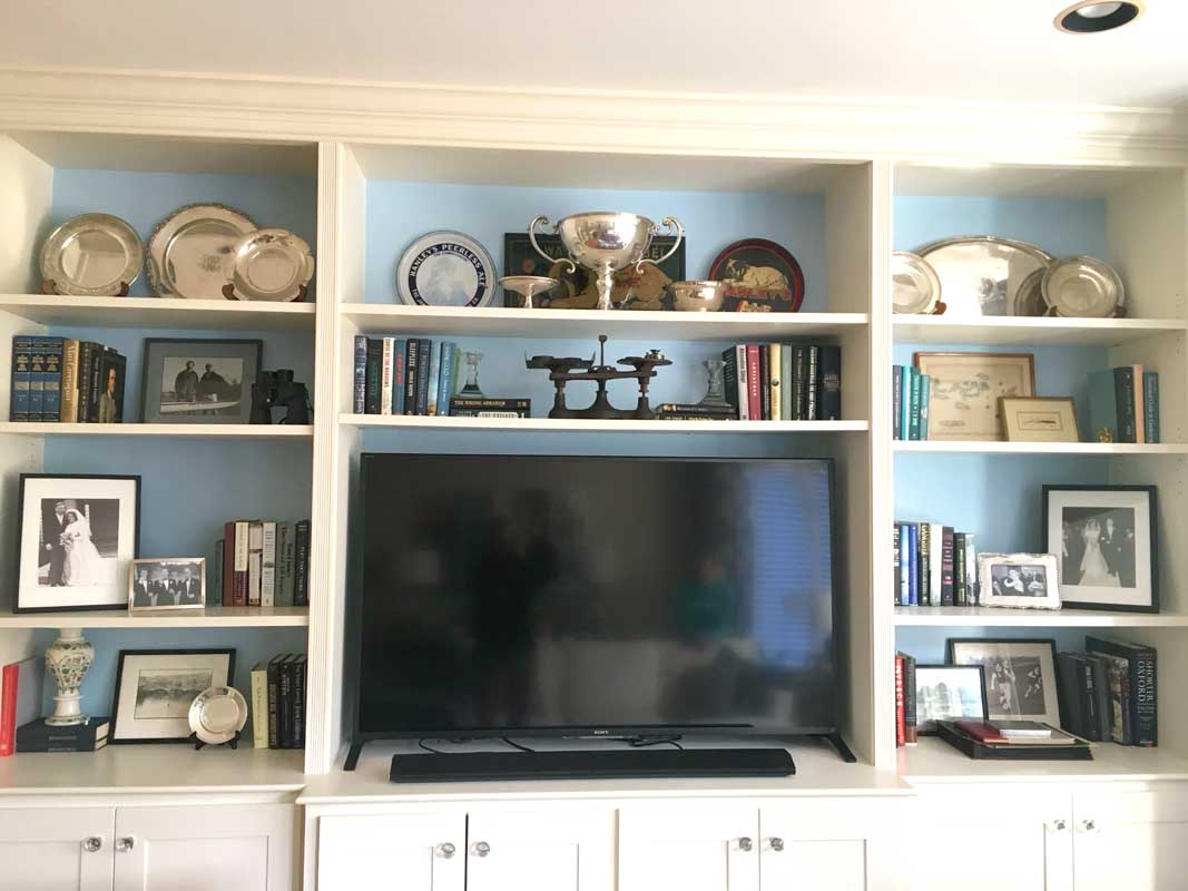 White bookshelf with TV arranged by Colleen Van Houten